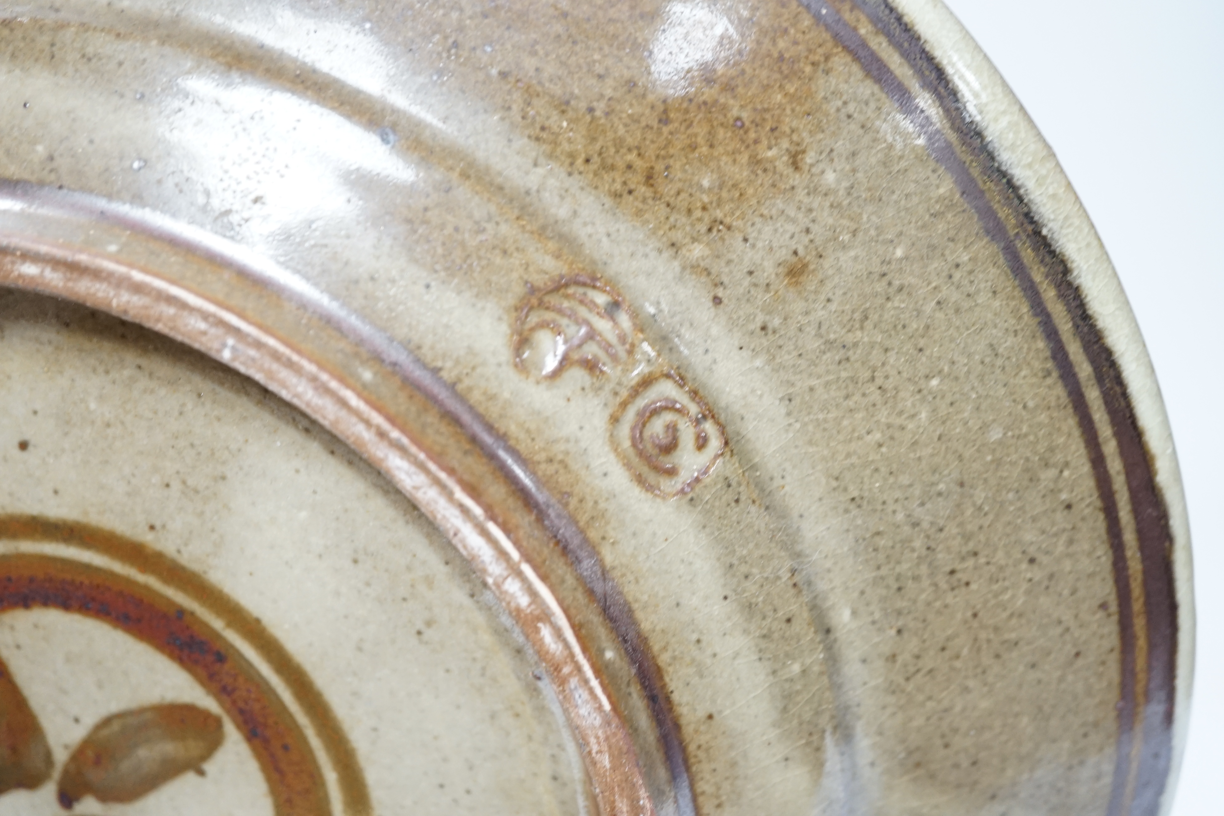 A Seth Cardew studio pottery stoneware dish, decorated with a bird and stylised flowers, 28cm in diameter